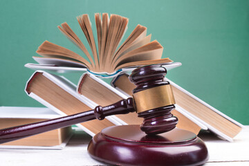 Law concept - Open law book, Judge's gavel, table in a courtroom or law enforcement office.