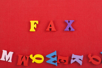 FAX word on red background composed from colorful abc alphabet block wooden letters, copy space for...