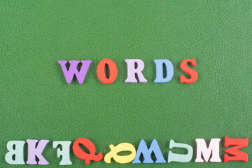 Words letters on green background composed from colorful abc alphabet block wooden letters, copy space for ad text. Learning english concept.