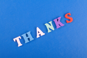 THANKS word on blue background composed from colorful abc alphabet block wooden letters, copy space...