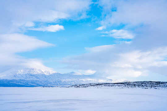 Frozen lake Tornetrask and snow covered mountains around Abisko, Sweden