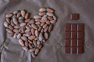 Cocoa beans. Heart. Chocolate bar. Bean-to-bar chocolate production. Brown background. 