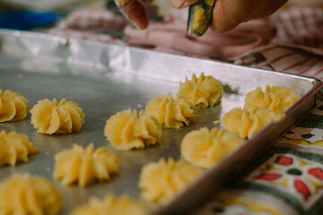 A syringe cake in the shape of a flower and filled with jam or raisins in the middle. Semprit cake is an Eid cake.