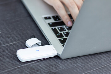 Close-up of businessman holding optional removable router to enhance the signal on a laptop for...