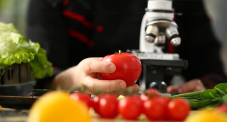 Microscope head on kitchen background vegetables concept nitrates