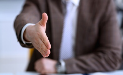 Man in suit and tie give hand as hello in office closeup. Friend welcome mediation offer positive...