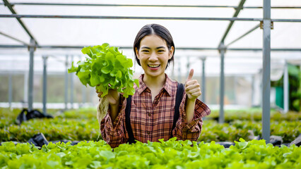 Portrait of young asian woman farmer wear plaid shirt talking on smartphone to video streaming review her organic vegetable farm, Smart farmer with technology device concept