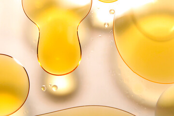 Golden oil bubbles float on a clear water background.