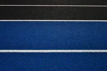 Fototapeta na wymiar Black and Blue Lanes on an All-Weather Sports Track