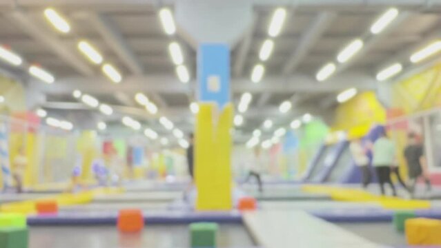 Children having fun and playing on trampolines in playroom, blur