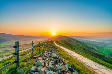 Stone footpath and wooden fence leading a long The Great Ridge in the English Peak District