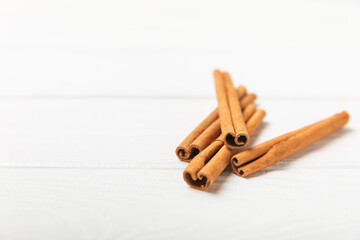 Cinnamon sticks on a textured wooden background. Cinnamon roll. Spicy spice for baking, desserts and drinks. Fragrant ground cinnamon. cinnamon powder Close-up. Place for text. copy space