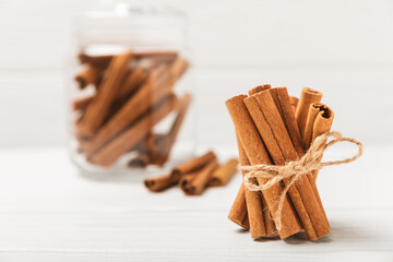 Cinnamon sticks on a textured wooden background. Cinnamon roll. Spicy spice for baking, desserts and drinks. Fragrant ground cinnamon. cinnamon powder Close-up. Place for text. copy space