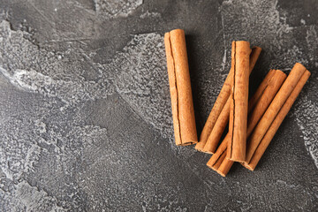 Cinnamon sticks on a textured wooden background. Cinnamon roll. Spicy spice for baking, desserts and drinks. Fragrant ground cinnamon. cinnamon powder Close-up. Place for text. copy space