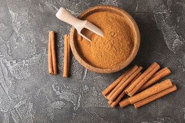 Cinnamon sticks on a textured wooden background. Cinnamon roll. Spicy spice for baking, desserts and drinks. Fragrant ground cinnamon. cinnamon powder Close-up. Place for text. copy space