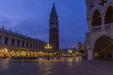 Fototapeta na wymiar An empty illuminated San Marco square with the bell tower and Doge Palace at blue hour on a winter evening, Venice, Veneto, Italy