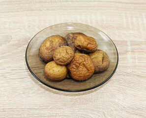 Plate with baked champignons, on wooden table.