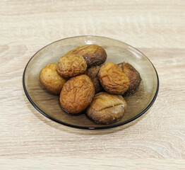 Plate with baked champignons, on wooden table.