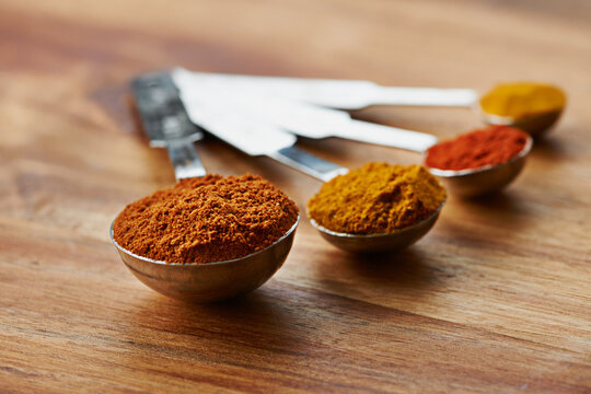 Measuring, spoon and spices with ingredients for food, culinary and flavor with variety or choice for cooking. Chef tools, ground seasoning for meal and cuisine, catering and natural with aroma