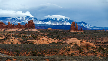 Snowy mountains behind hoodoos in Arches national park