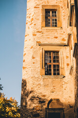Exterior of Czocha castle in Poland. Old stone walls and tall windows covered with sunset sunlight. - 778299953