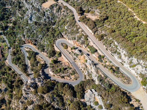 Winding mountain road in Sardinia, Italy &ndash; aerial view of scenic serpentine through rugged terrain