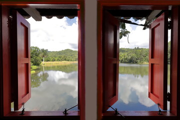 Window with a view in the bedroom of a local house overlooking Lago San Juan Lake in Las Terrazas...