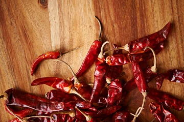 Fotobehang Above, chilli and board for pepper, spices and flavor for dry ingredient for cooking, cuisine and food. Paprika, cayenne or condiment and spicy with red colour for capsicum and heat in dish or meal © peopleimages.com