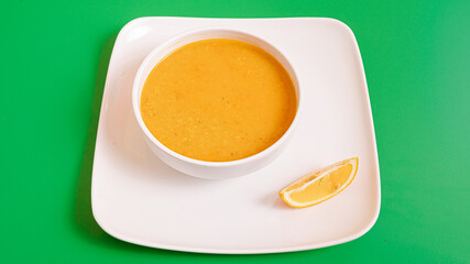 Lentil soup bowl top view isolated on green