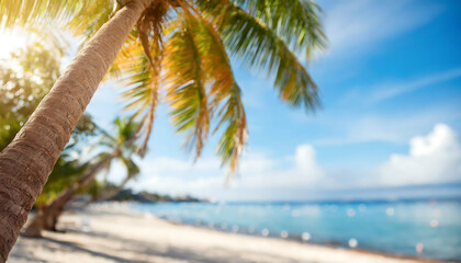 A palm tree is in the foreground of a beach scene. The palm tree is the main focus of the image, and the beach is the background - obrazy, fototapety, plakaty