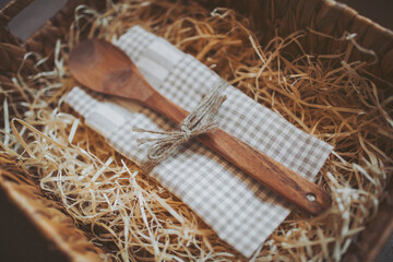 wooden spoon and kitchen towel in a box with straw. Cooking concept. empty wooden spoon on the...