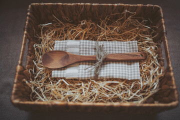 wooden spoon and kitchen towel in a box with straw. Cooking concept. empty wooden spoon on the...
