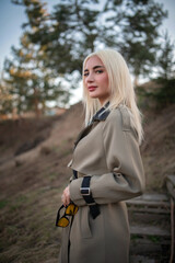 Portrait of a young beautiful blonde girl in the spring near the river.