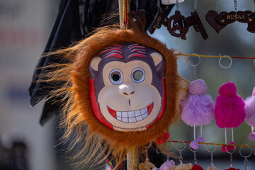 Handmade mask of monkey animal mask hanging at fair. Selective focus.