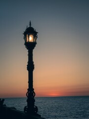 Fototapeta na wymiar Sunset and a lonely lamppost at the avenida Campo del Sur in Cadiz Spain