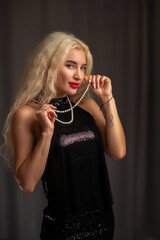 Portrait of a young beautiful blonde girl in dark clothes.