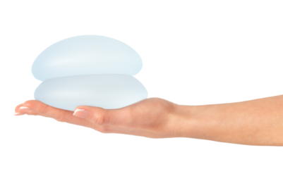 Female holding breast implants on hand, isolated