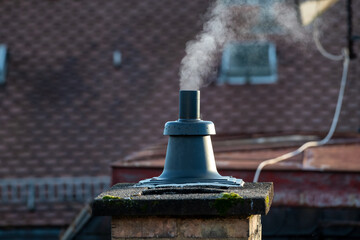 Rauch steigt aus einem Schornstein auf einem Hausdach