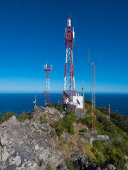 Telecommunication tower with antennas and blue sky background at Pico do Facho hill viewpoint, Machico, Madeira, Portugal - 778332939