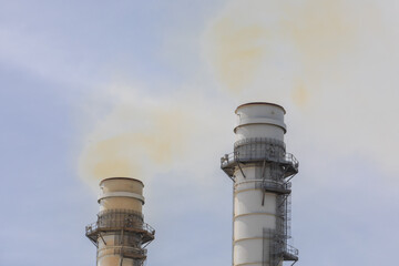 Industrial smoke stacks belching yellow colored pollution
