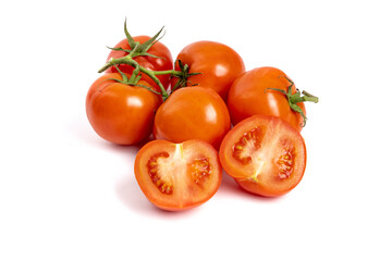 A bunch of fresh ripe red greenhouse tomatoes on the vine with one tomato cut open isolated on white