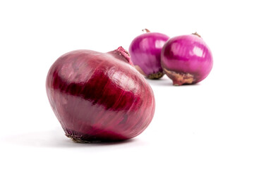 Large and small red onions isolated on white with selective focus