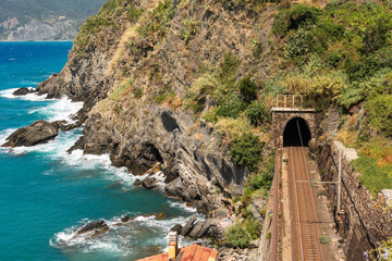 railroad tracks in Vernazza near a sea, there trains between five Cinque Terre towns are going