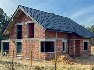 A single-family house built of ceramic blocks with a tile roof in a shell state. - 778351706