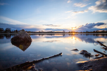 View from the shore into the distance and a sunset at the lake. The surroundings and the beautiful...