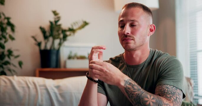 Healing, eft tapping and calm man on sofa for anxiety, mental health and holistic wellness. Peace, relax and male person with reiki meditation on hands for zen, balance and body energy at home.