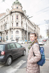 Beautiful woman with bagpack and sunglasses standing on the street in the Belgrade city, Serbia