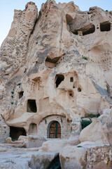 Time-worn cave houses carved into the rock face of Cappadocia, standing as a testament to ancient...