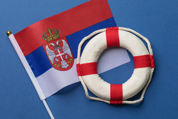 Serbian flag and lifebuoy on a colored background, concept on the theme of help