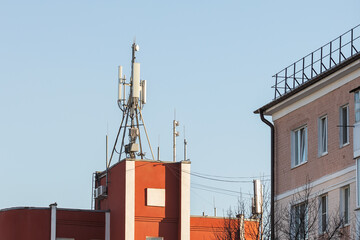 Cell phone towers on the roof of a building near residential buildings, a concept on the topic of the dangerous effects of radio waves on human health